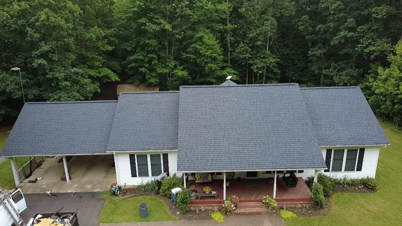 Crew at work on landscaping cleanup after a roof installation