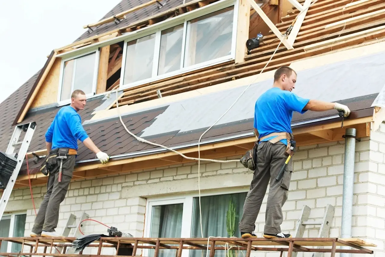 Roofing crew installing shingles on a residential roof