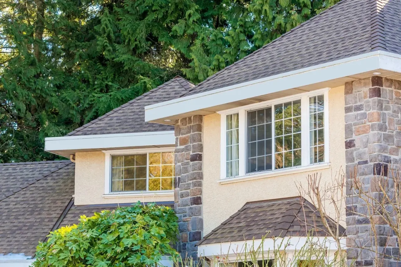 Completed brown architectural shingle roof on a stone and stucco home