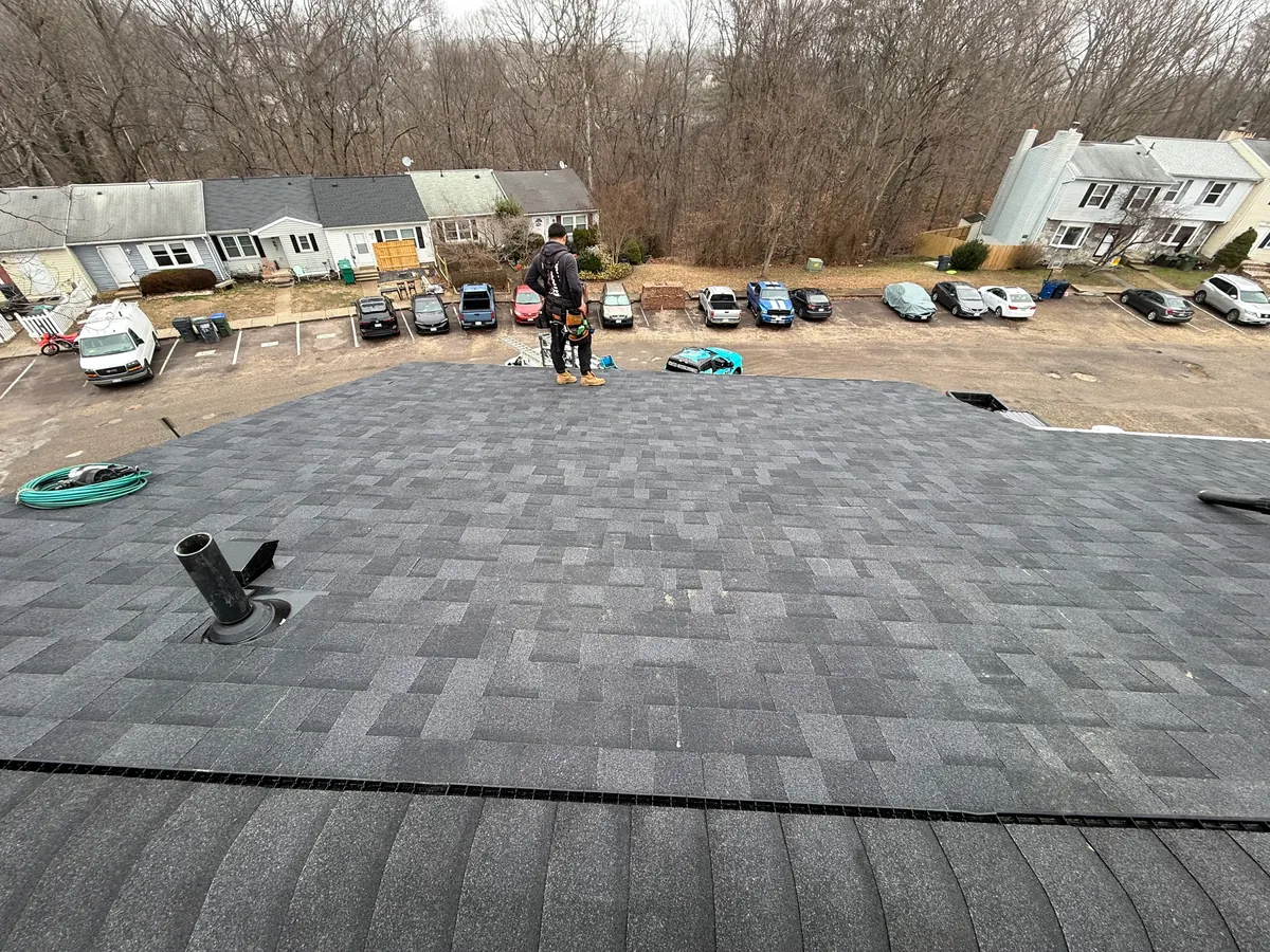 Roofing crew installing a shingle roof, aerial view