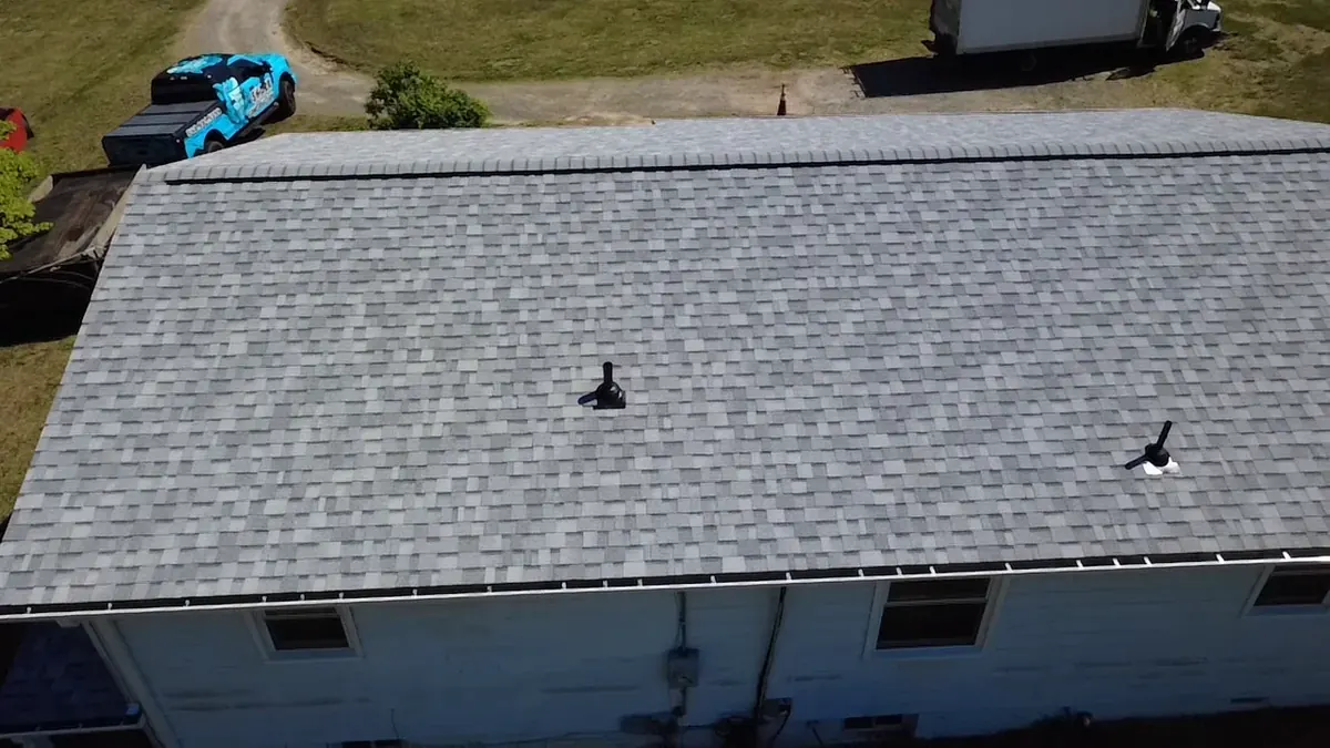 Roof installation in progress with crew and ladders